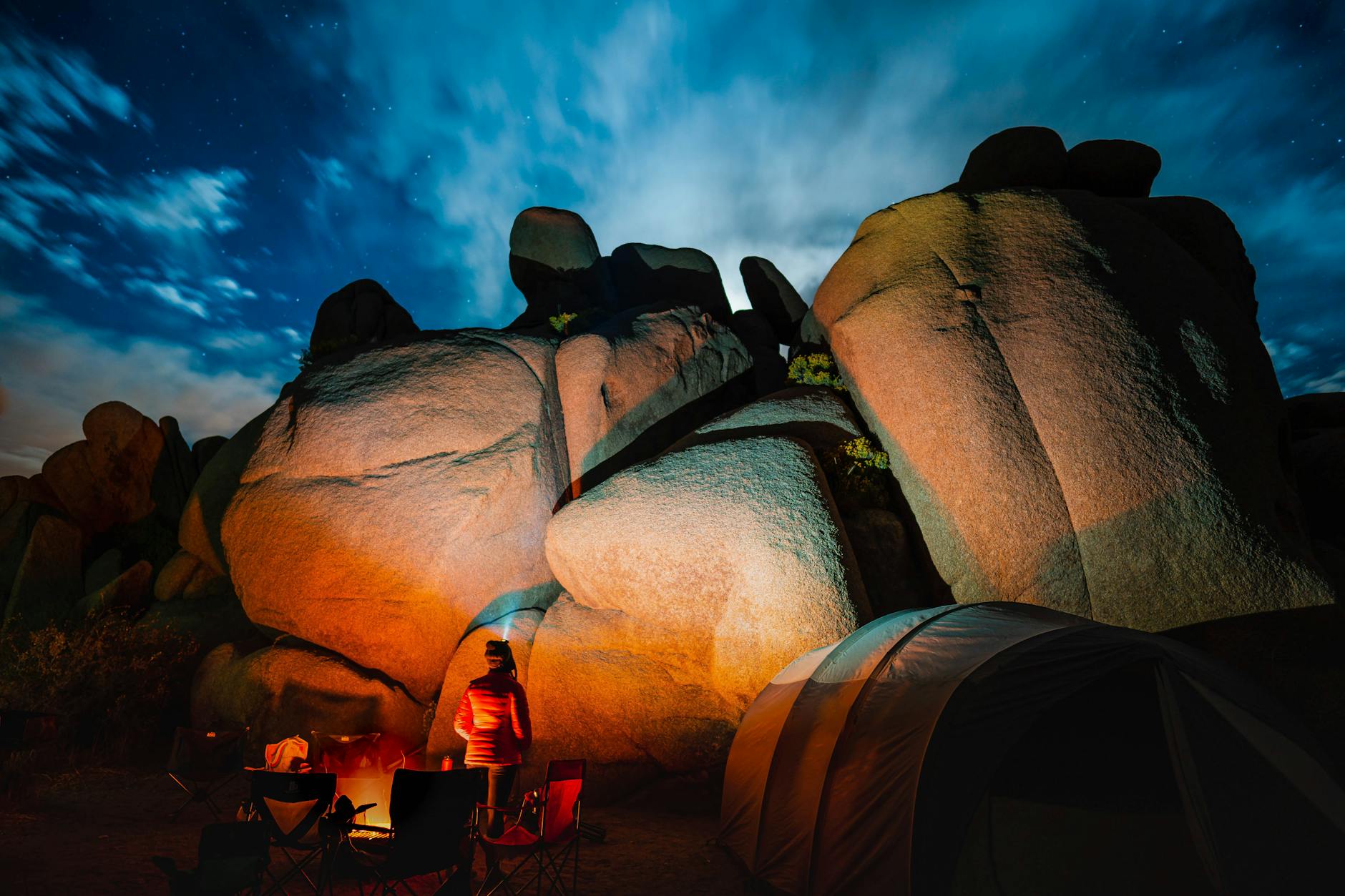 Nocny biwak z namiotem i ogniskiem pod gwiazdami przy skalistym wybrzeżu